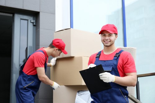 Local moving helper carrying furniture near Southfields flats and terraces